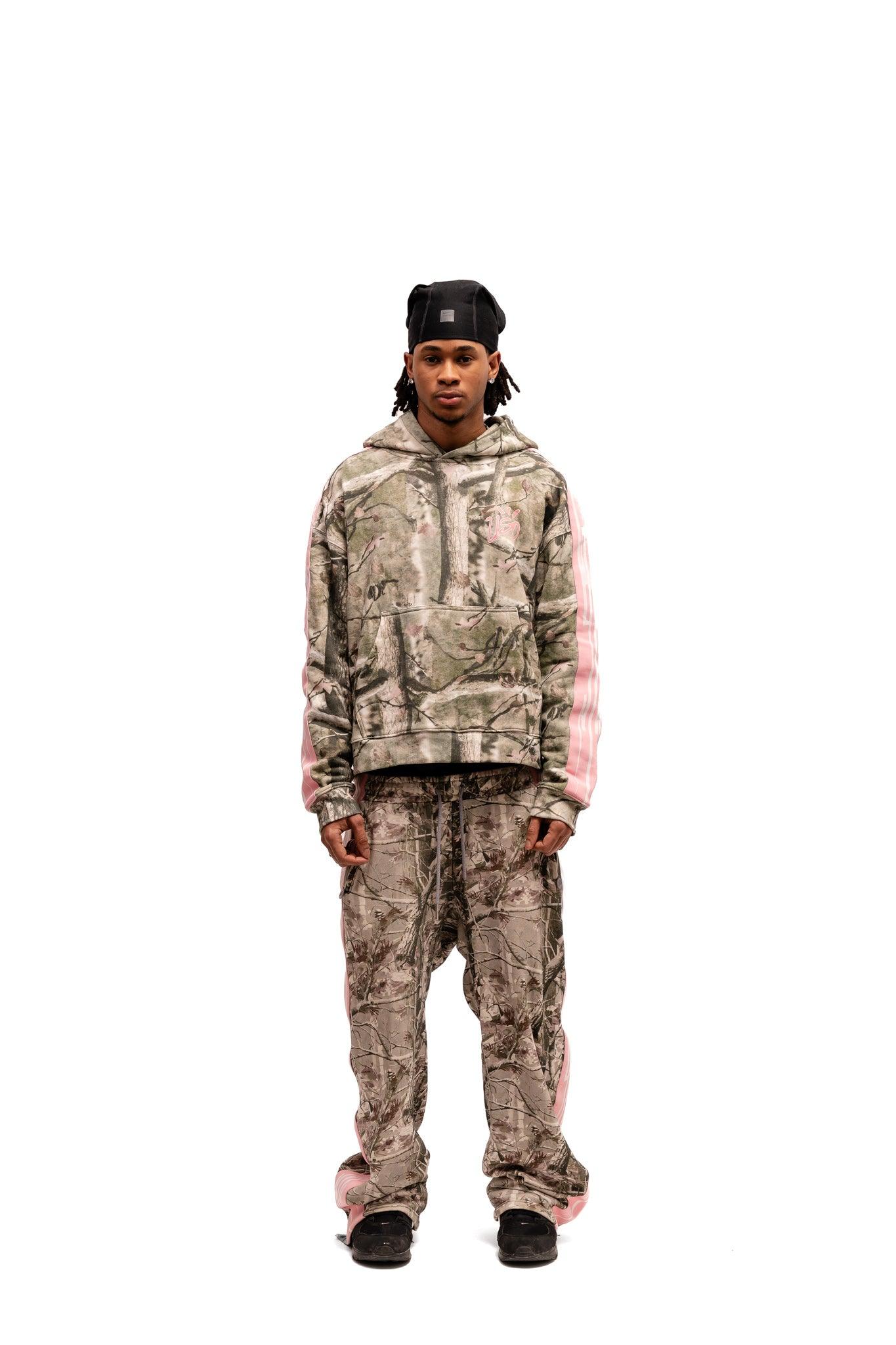 Model wearing Uso Wanai Real Tree Camo Hoodie with pink accents in oversized boxing fit, styled with matching pants