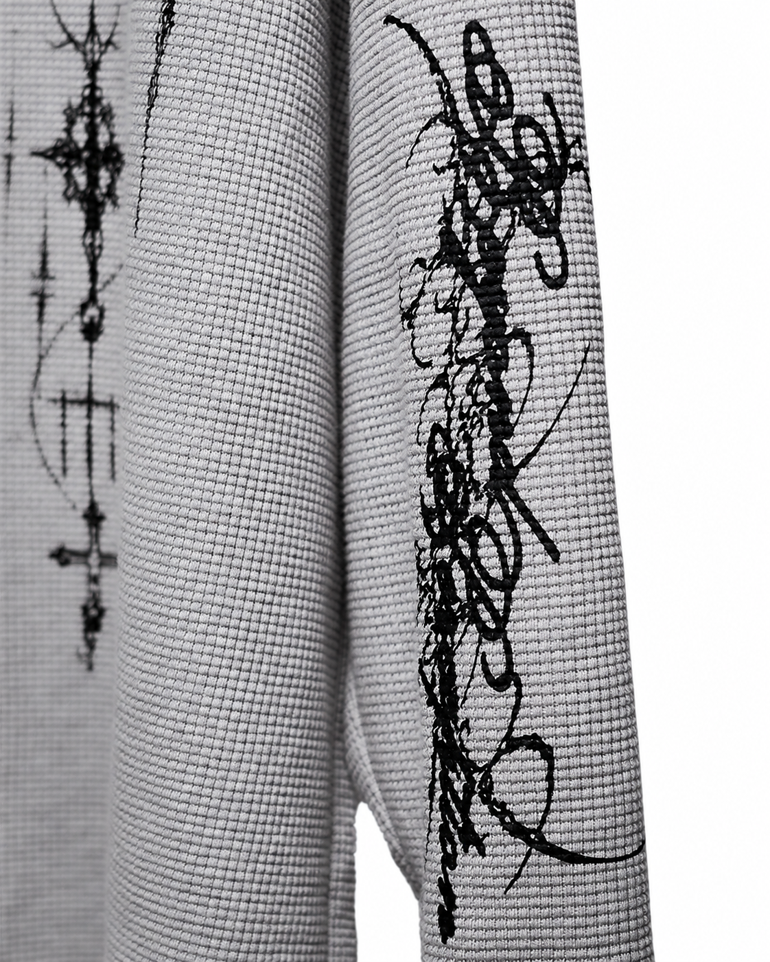 Close-up of the Cyber Sigilism Thermal 275 GSM waffle knit texture and black sleeve print