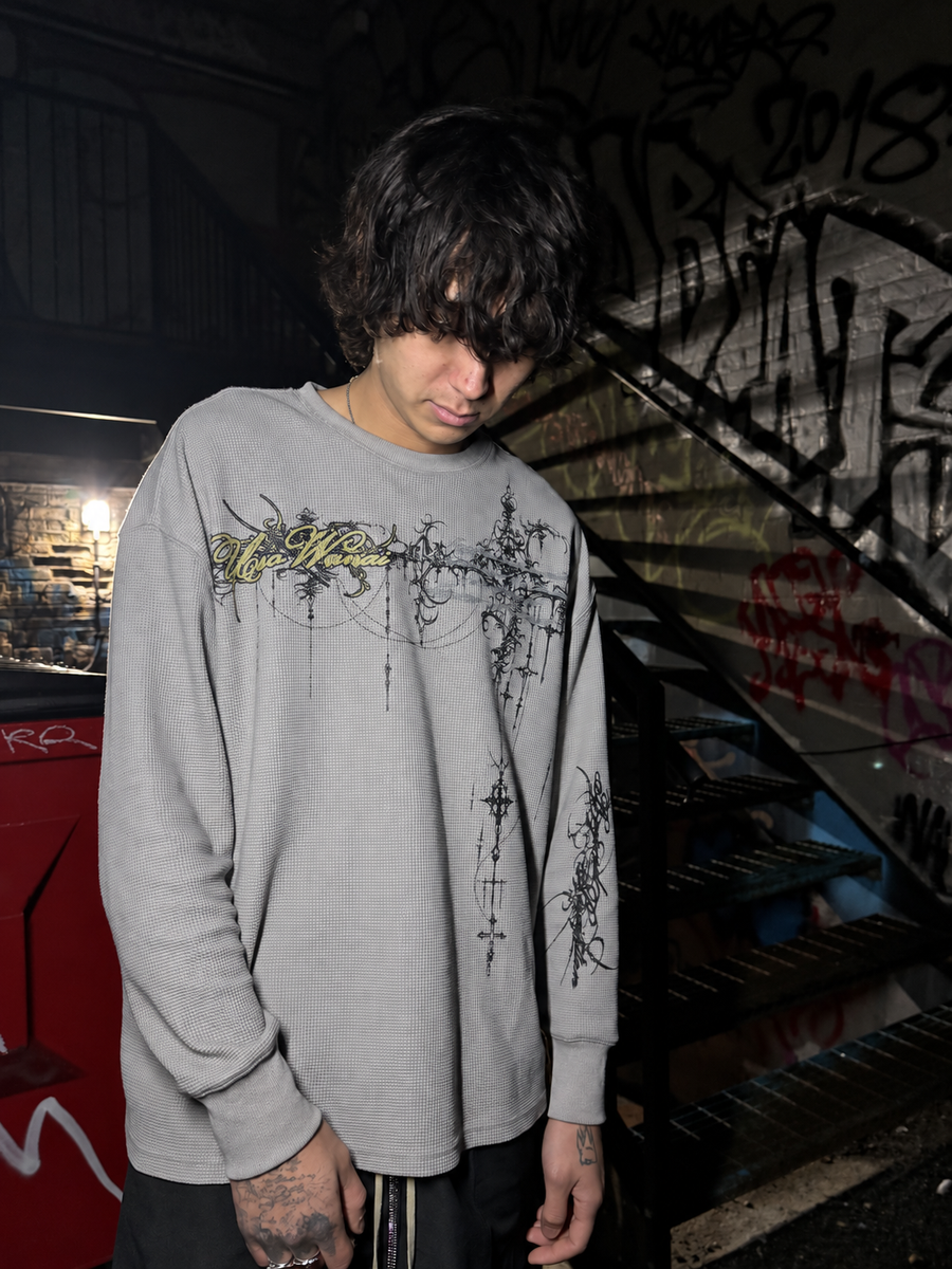Model wearing the Cyber Sigilism Thermal grey waffle knit long sleeve, relaxed boxy fit, Uso Wanai script and chest print